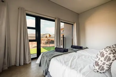a bedroom with a bed and a large window at Highland Gate Golf and Trout Estate 857 in Dullstroom