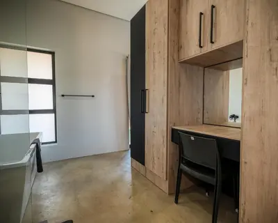 a kitchen with wooden cabinets and a table with a chair at Highland Gate Golf and Trout Estate 857 in Dullstroom