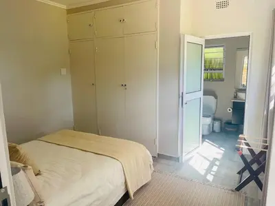 a bedroom with a bed and a bathroom at Whitehouse cottage in White River