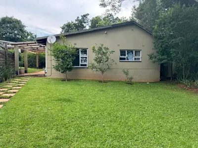 a small house with a lawn in front of it at Whitehouse cottage in White River