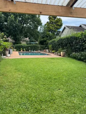 a backyard with a swimming pool and green grass at Whitehouse cottage in White River