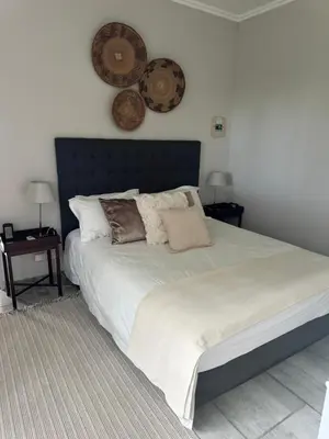 a bedroom with a large bed with pillows on it at Whitehouse cottage in White River