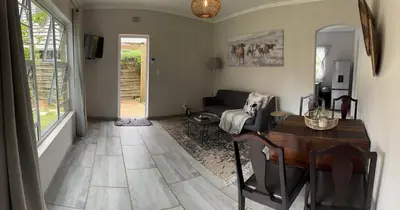 a living room with a table and a couch at Whitehouse cottage in White River