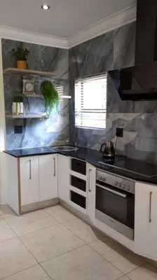 a kitchen with a black counter top and a stove at Pecanwood Treasure Hartbeespoort Dam in Hartbeespoort