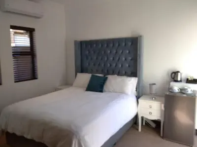 a bedroom with a large bed with a large headboard at Pecanwood Treasure Hartbeespoort Dam in Hartbeespoort