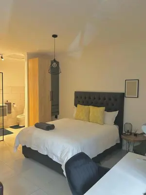 a bedroom with a large bed with a black headboard at Apartment close to Menlyn Maine in Pretoria