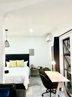 a bedroom with a bed and a desk and a chair at Apartment close to Menlyn Maine in Pretoria