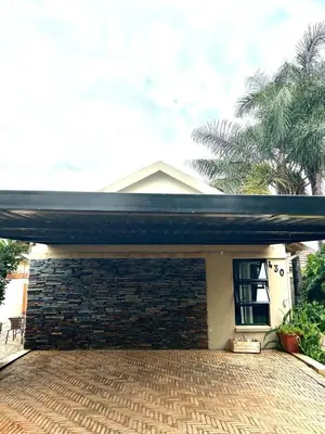 a house with a brick wall and a garage at Apartment close to Menlyn Maine in Pretoria