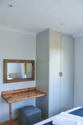 a bedroom with a mirror and a bed at Letlotse Lodge in Hammanskraal
