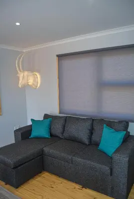 a couch with two blue pillows in a living room at Letlotse Lodge in Hammanskraal