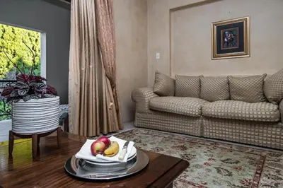 a living room with a couch and a table with fruit on it at Villa Amor in Pretoria