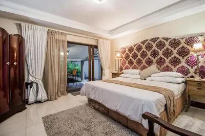 a bedroom with a large bed with a large window at Villa Amor in Pretoria