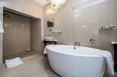 a bathroom with a white tub and a sink at Villa Amor in Pretoria
