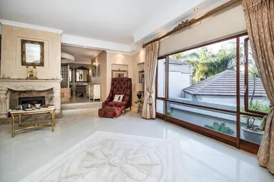 a living room with a fireplace and a large window at Villa Amor in Pretoria