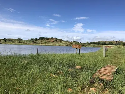 a sign in the grass next to a body of water at Woolly Bugger Farm in Tonteldoos