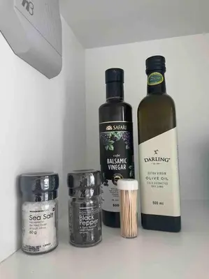 three bottles of wine sitting on a shelf next to sidx sidx at Ellipse Waterfall Luxury Apartment in Midrand