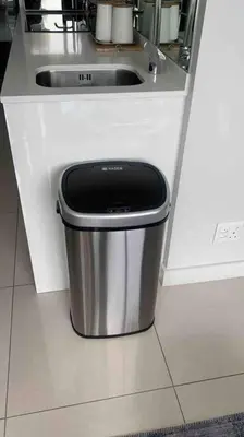 a trash can sitting under a sink in a kitchen at Ellipse Waterfall Luxury Apartment in Midrand