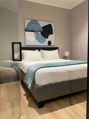 a bedroom with a bed and a painting on the wall at Ellipse Waterfall Luxury Apartment in Midrand