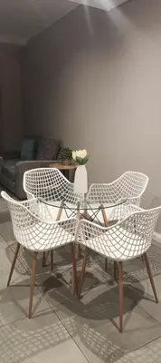 two white chairs and a table with a vase of flowers at Menlyn Maine Trilogy Penthouse 42 in Pretoria