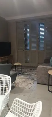 a living room with a bed and a tv at Menlyn Maine Trilogy Penthouse 42 in Pretoria