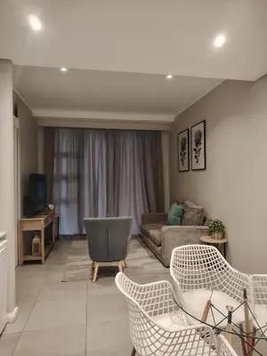 a living room with a couch and chairs at Menlyn Maine Trilogy Penthouse 42 in Pretoria