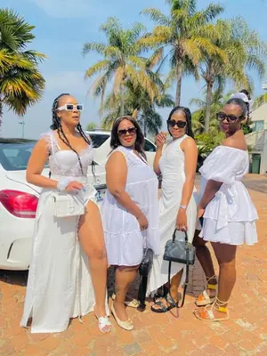 a group of women in white dresses standing next to a car at The Holiday House Harties in Hartbeespoort