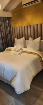 a large white bed with a stuffed animal on it at The Holiday House Harties in Hartbeespoort
