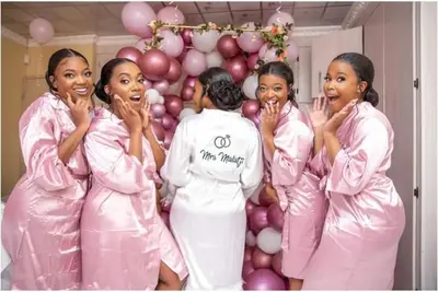 a group of women in pink suits standing in front of a balloon at The Holiday House Harties in Hartbeespoort