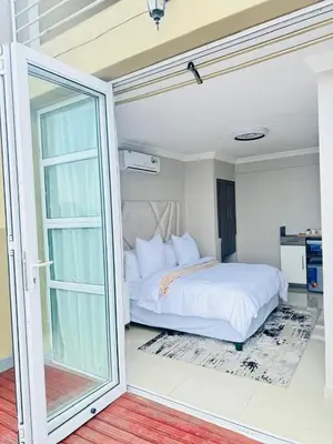 a bedroom with a bed and a sliding glass door at The Holiday House Harties in Hartbeespoort