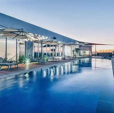 a large pool with blue water in front of a building at The Comfort AirB&B - On the 8th floor luxury 1 bedroom apartment with views in Pretoria