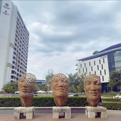 threeulptures of heads are sitting in a park at The Comfort AirB&B - On the 8th floor luxury 1 bedroom apartment with views in Pretoria