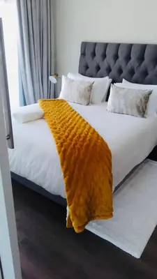 a bed with a brown blanket on top of it at The Comfort AirB&B - On the 8th floor luxury 1 bedroom apartment with views in Pretoria