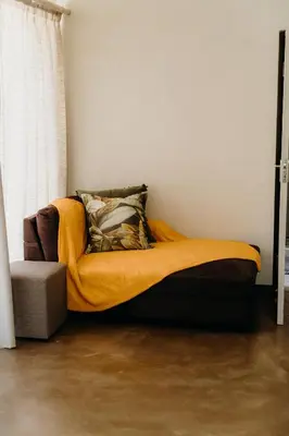a bed with a yellow blanket in a room at Ruzelle Family House in Hazyview