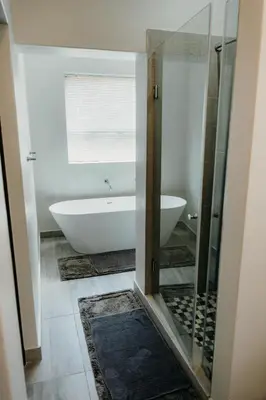 a bathroom with a tub and a toilet and a sink at Ruzelle Family House in Hazyview