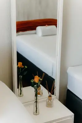 a bedroom with a bed and two vases with flowers at Ruzelle Family House in Hazyview