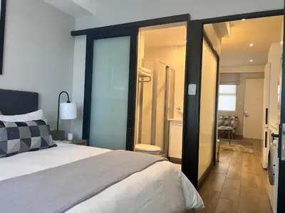 a bedroom with a large bed and a bathroom at The Regency Cosy Apartment- 419 in Pretoria