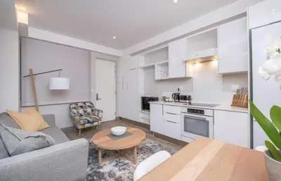 a kitchen and living room with a couch and a table at The Regency Cosy Apartment- 419 in Pretoria