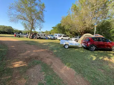 a group of cars parked in a field with tents at De Rust Campsite in Hammanskraal