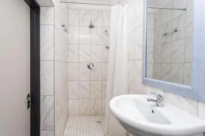 a white bathroom with a sink and a shower at Botanik in Pretoria
