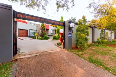 a building with a parking lot in front of it at Botanik in Pretoria