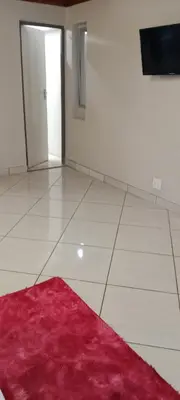 a room with a red rug on a white floor at Botanik in Pretoria