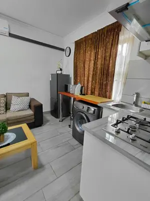a kitchen and living room with a stove and a couch at The Plum in Louis Trichardt