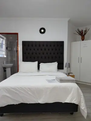 a bedroom with a large bed with a black headboard at The Plum in Louis Trichardt