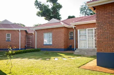 a brick house with a yard in front of it at The Plum in Louis Trichardt