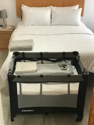 a bed with a black frame with towels on it at The Plum in Louis Trichardt
