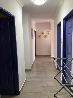 a hallway with blue doors and a tile floor at The Plum in Louis Trichardt