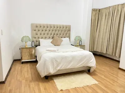 a bedroom with a large bed and two night stands at Tuscany Guesthouse in Midrand