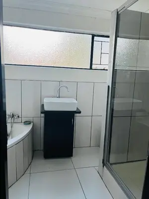 a bathroom with a sink and a bath tub at Genesis Guesthouze in Bela-Bela