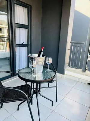 a table with two glasses and a bottle of wine at The Blyde in Pretoria