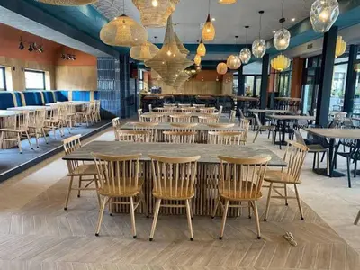 a dining room with tables and chairs and chandeliers at The Blyde in Pretoria